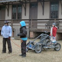 Three scouts demonstrate the positions on a dog sled team.