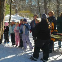 Home schoolers learn about dog sledding in the snow.
