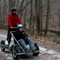 On by! Catherine and her guest dryland dog sledding on the NCR trail.