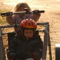 A young rider lets his sister drive.